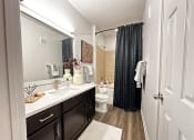 Thumbnail 45 of 84 - a bathroom with a shower and a toilet and a sink at Grand Villas Apartments, Katy