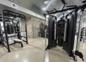 Thumbnail 21 of 63 - a gym with weights machines and other equipment in a building with galvanized ceilings at Edge 35, Indianapolis