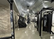 Thumbnail 27 of 63 - a gym with cardio machines and a brick wall at Edge 35, Indianapolis