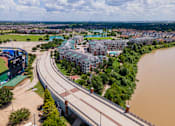 Thumbnail 45 of 52 - Bridge over a river with a road and buildings on both sides at Imperial Lofts, Sugar Land, 77498