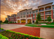 Thumbnail 1 of 24 - an exterior view of an apartment building at sunset at Imperial Lofts, Sugar Land, 77498