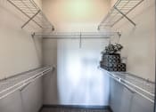 Thumbnail 30 of 38 - a walk in closet with empty shelves and a white curtain  at Waterstone at Cinco Ranch, Texas, 77450