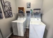 Thumbnail 33 of 38 - two washers and a dryer in a laundry room with a shelf above them at Waterstone at Cinco Ranch, Katy, Texas