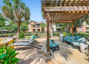 Thumbnail 28 of 38 - a patio with lounge chairs and a pergola at River Pointe, Conroe, TX, 77304
