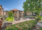 Thumbnail 24 of 38 - our apartments offer a courtyard with tables and chairs and plants at River Pointe, Texas
