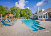Thumbnail 12 of 27 - a resort style pool with blue chairs and a building with trees  at Butternut Ridge, Ohio