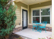 Thumbnail 14 of 39 - a patio with blue chairs and a table and a door at Sovereign at Overland Park, Overland Park Kansas