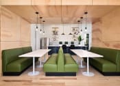 Thumbnail 23 of 39 - a modern living room with green couches and a white table at Sovereign at Overland Park, Kansas