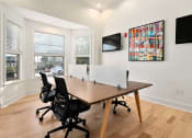 Thumbnail 30 of 39 - a conference room with a wooden floor and a table with chairs at Sovereign at Overland Park, Kansas, 66213
