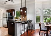 Thumbnail 2 of 39 - a kitchen with a bar and a table with stools at Sovereign at Overland Park, Overland Park, KS 66213