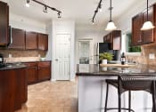 Thumbnail 4 of 39 - a kitchen with brown cabinets and a counter top at Sovereign at Overland Park, Kansas, 66213