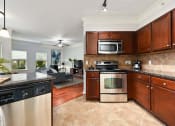 Thumbnail 1 of 39 - a kitchen with stainless steel appliances and wooden cabinets at Sovereign at Overland Park, Overland Park, KS 66213