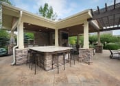 Thumbnail 32 of 39 - a covered patio with an outdoor kitchen and bar at Sovereign at Overland Park, Overland Park Kansas