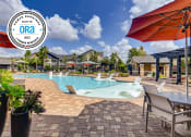 Thumbnail 1 of 29 - a swimming pool with chairs and umbrellas at the resort at Avenues at Shadow Creek Ranch, Pearland, TX, 77584