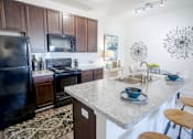 Thumbnail 3 of 62 - A kitchen with a black refrigerator and a granite countertop. at Overland Park, Pickerington, 43147