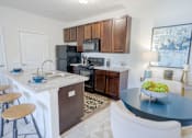 Thumbnail 1 of 62 - A kitchen with a black refrigerator, white countertops, and wooden cabinets. at Overland Park, Pickerington, OH