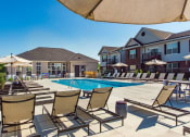 Thumbnail 6 of 64 - lounge chairs by pool with apartment buildings in the background at Overland Park, Ohio