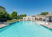 Thumbnail 29 of 63 - A large swimming pool with a blue tiled edge and a white fence around it.