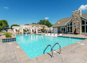 Thumbnail 28 of 63 - A large swimming pool with a stone building in the background.
