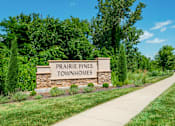 Thumbnail 3 of 63 - A sign for Prairie Pines Townhomes stands in front of a green lawn.