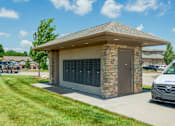 Thumbnail 35 of 63 - A stone and concrete building with a brown roof and a van parked in front.