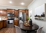 Thumbnail 9 of 63 - A modern kitchen with a wooden table and chairs.