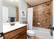Thumbnail 13 of 63 - A bathroom with a brown tiled shower area and a white toilet.