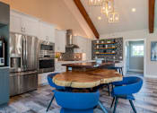 Thumbnail 41 of 63 - A modern kitchen with a blue chair and a wooden table.