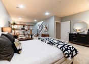 Thumbnail 20 of 63 - A bedroom with a large bed and a dresser with a mirror.
