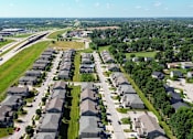 Thumbnail 51 of 63 - A suburban neighborhood with rows of houses and a highway in the background.