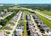 Thumbnail 53 of 63 - A bird's eye view of a residential area with rows of houses and a swimming pool in the middle.