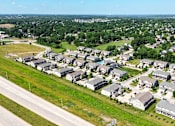 Thumbnail 60 of 63 - A bird's eye view of a residential area with houses and greenery.
