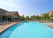 Thumbnail 34 of 39 - a swimming pool with lounge chairs and buildings in the background at Sovereign at Overland Park, Kansas, 66213