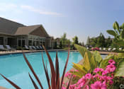 Thumbnail 37 of 39 - a swimming pool with pink flowers in front of a house at Sovereign at Overland Park, Overland Park, 66213