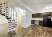 Thumbnail 5 of 43 - A kitchen area with a black fridge and wooden cabinets at Spring Creek Townhomes Apartments, Illinois 62702