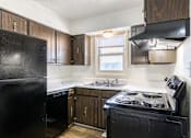 Thumbnail 1 of 43 - A black fridge and stove in a kitchen with wooden cabinets at Spring Creek Townhomes Apartments, Springfield 62702