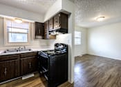 Thumbnail 4 of 43 - A kitchen with a black fridge and wooden cabinets at Spring Creek Townhomes Apartments, Springfield, IL 62702
