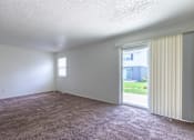 Thumbnail 17 of 43 - A room with a carpeted floor and a sliding glass door at Spring Creek Townhomes Apartments, Springfield, IL 62702