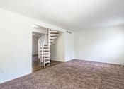Thumbnail 12 of 43 - A room with a carpeted floor and a spiral staircase at Spring Creek Townhomes Apartments, Springfield, IL 62702