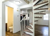 Thumbnail 11 of 43 - A white staircase with a carpeted runner leads to a second floor at Spring Creek Townhomes Apartments, Springfield, Illinois