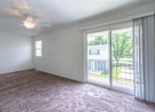 Thumbnail 13 of 43 - A room with a ceiling fan and sliding glass doors at Spring Creek Townhomes Apartments, Illinois 62702