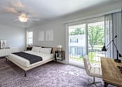 Thumbnail 42 of 43 - A bedroom with a large bed and a balcony view at Spring Creek Townhomes Apartments, Springfield, IL