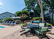 Thumbnail 16 of 46 - Poolside area with table and chairs at Springhill Apartments, Overland Park, 66213