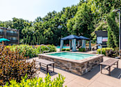 Thumbnail 21 of 42 - A pool area with a blue canopy and benches.