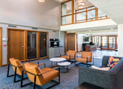 Thumbnail 4 of 42 - A living room with a grey couch and orange chairs.