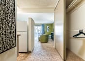 Thumbnail 34 of 42 - A hallway with a white fridge and a green chair.