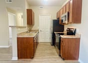 Thumbnail 2 of 66 - A kitchen with wooden cabinets and a stainless steel appliances at The Greyson, Hilliard, 43026