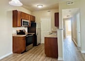 Thumbnail 12 of 66 - A kitchen with wooden cabinets and a stainless steel refrigerator at The Greyson, Hilliard OH