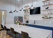 Thumbnail 25 of 53 - A kitchen with a white countertop and blue cabinets at Sovereign at Overland Park Apartments, Overland Park Kansas