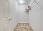 Thumbnail 19 of 53 - Spacious walk-in closet with built-in shelving and carpet flooring at Sovereign at Overland Park Apartments, Overland Park Kansas